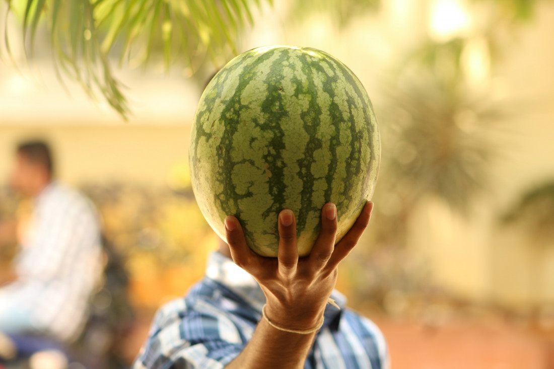 selective-focus-photo-of-man-raising-the-watermelon-974561